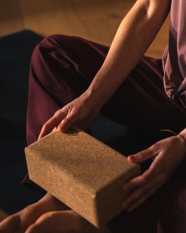 Eine Frau macht Yoga mit einem Yoga-Block.