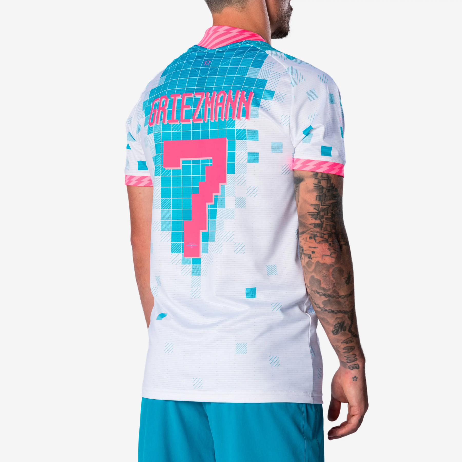 Rückansicht eines Spielers in einem weiß-türkisfarbenen Fußballtrikot mit der pinken Aufschrift „Griezmann“ und der Rückennummer 7.