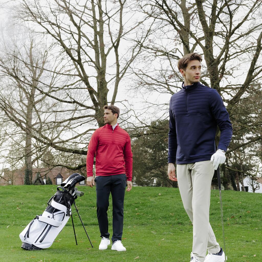 Zwei Männer in Sportbekleidung stehen mit Golfschläger und Bag auf dem Grün eines Golfplatzes.