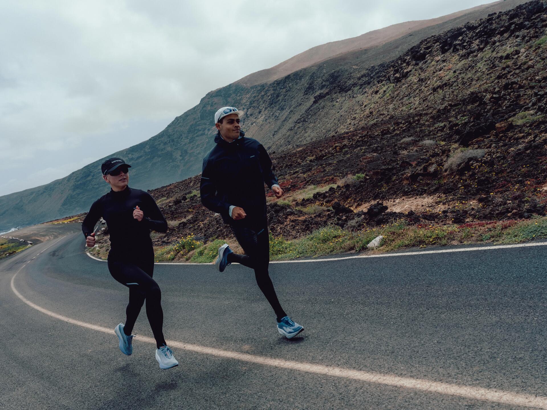 Young girl running in black sports clothing in the mountains.