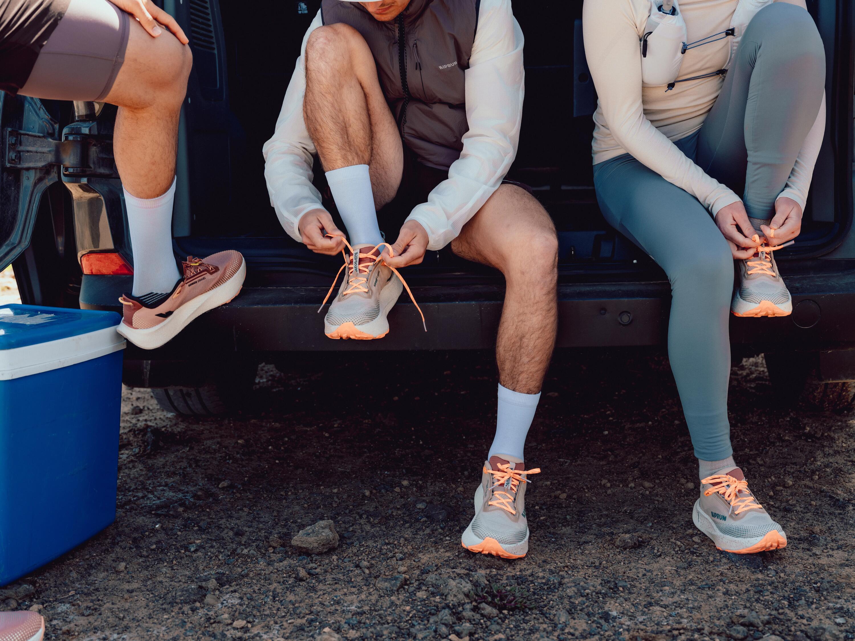 3 Läufer binden sich die Laufschuhe