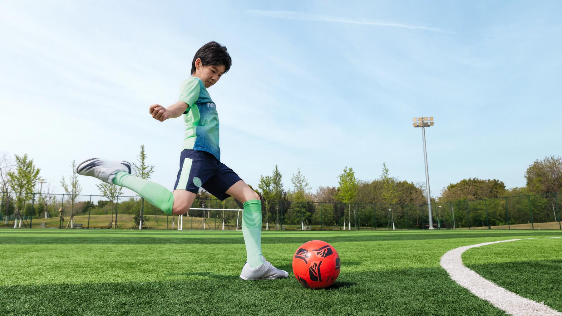 Ein Junge schießt in Fußballkleidung aufs Tor