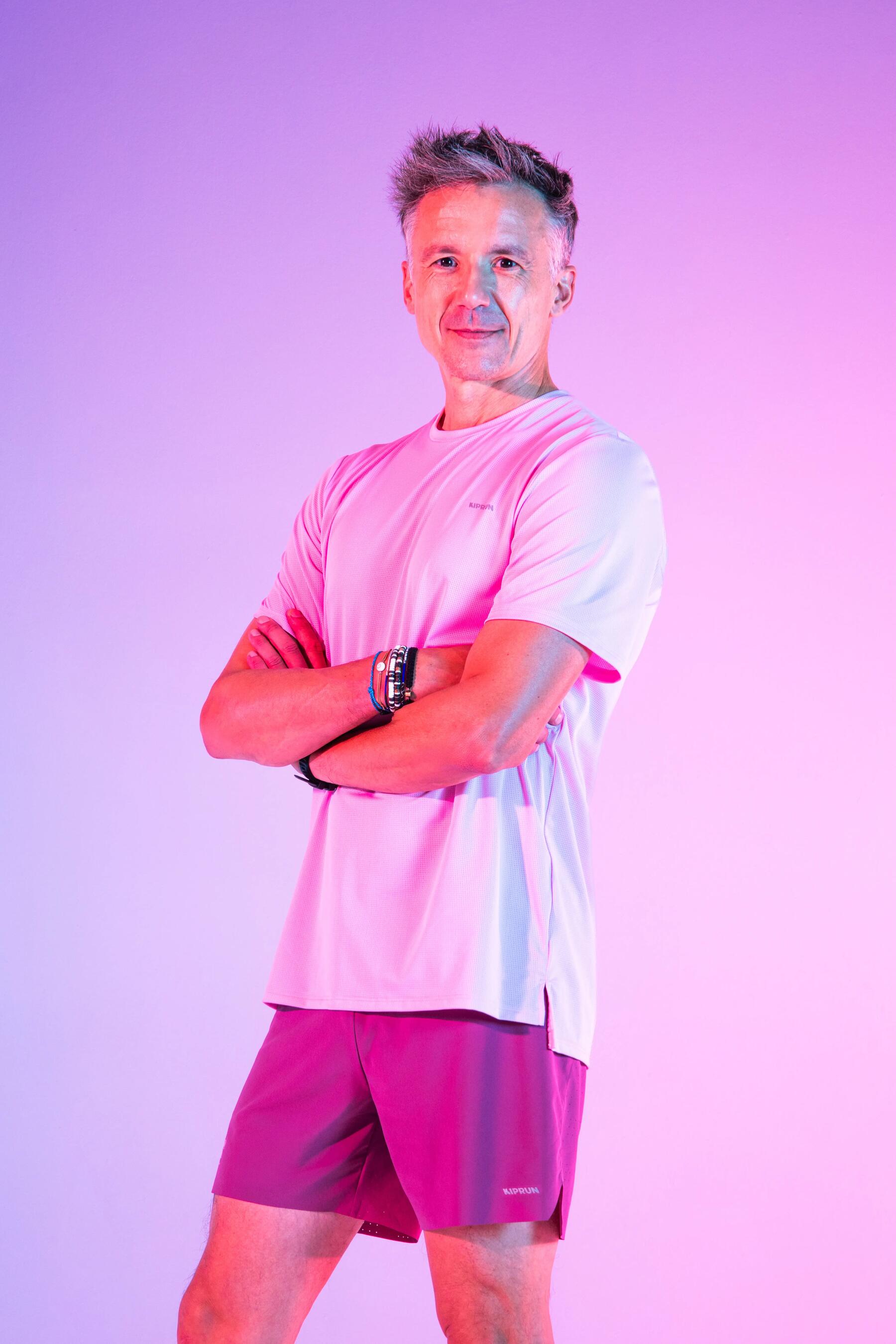 Mężczyzna w stroju sporotwym biegnący chodnikiem