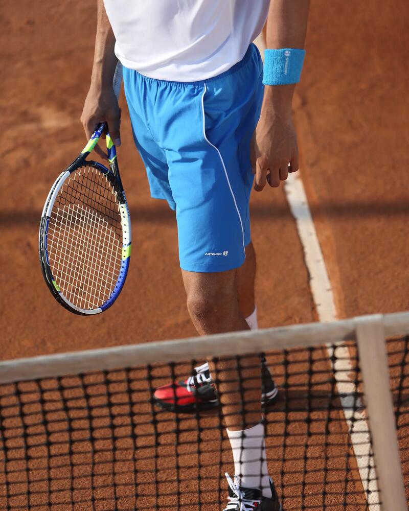 Ein Tennisspieler steht auf dem Tennisplatz am Netz