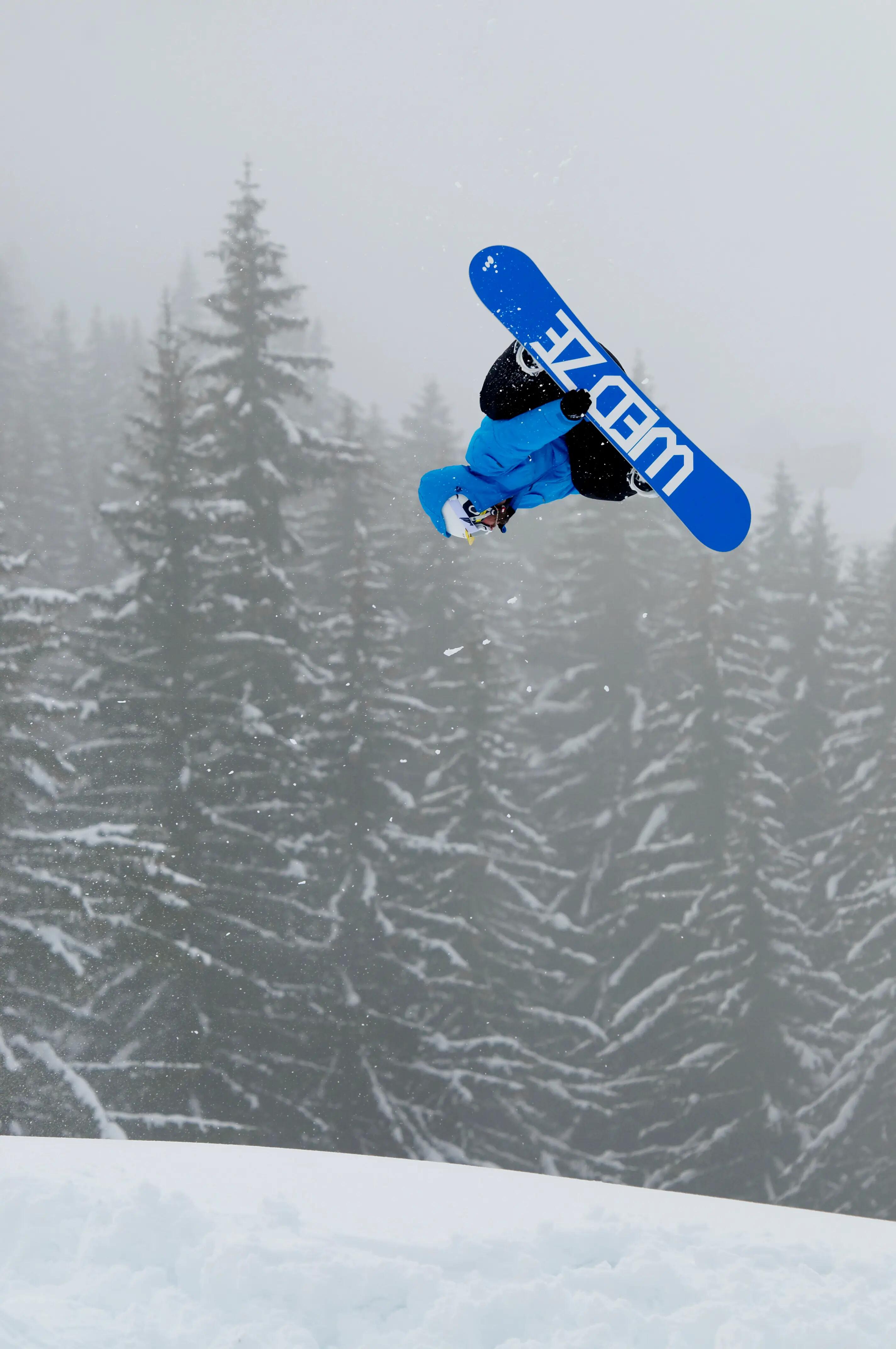 Mann macht einen Stunt auf einem Wedze Snowboard