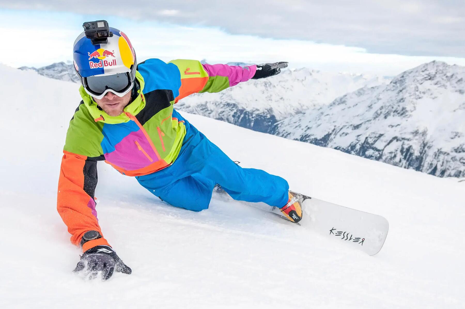 Mężczyzna w kasku narciarskim z zamontowaną kamerą GoPro jeżdżacy na snowboardzie