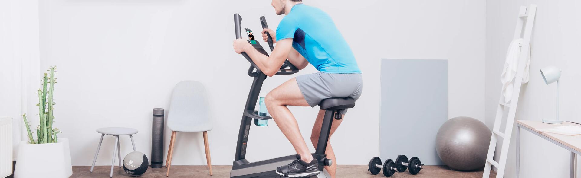 mężczyzna jadący na rowerku stacjonarnym w odzieży sportowej