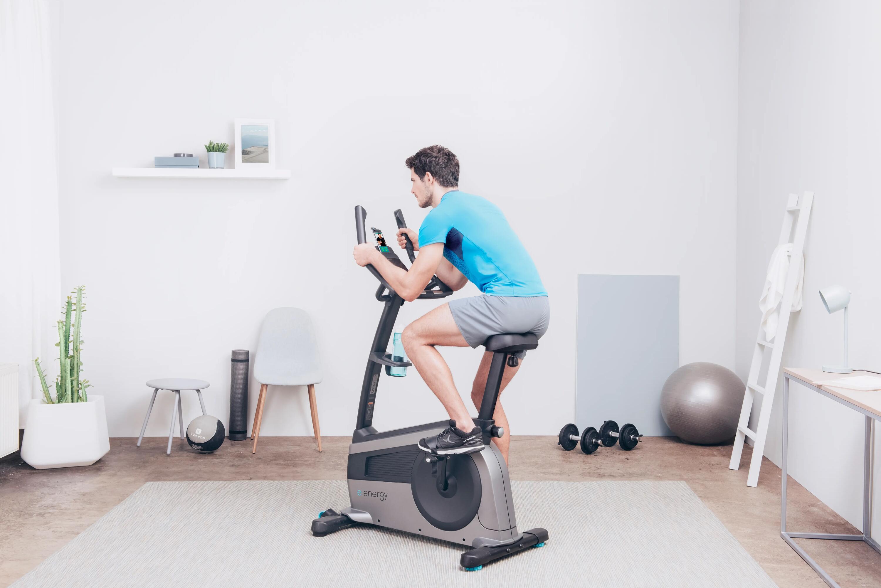 mężczyzna jadący na rowerku stacjonarnym w odzieży sportowej