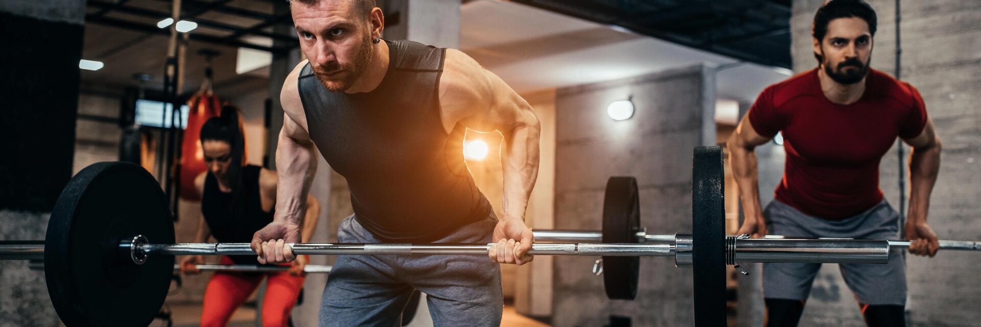 Ludzie na siłowni ćwiczący martwy ciąg trap bar