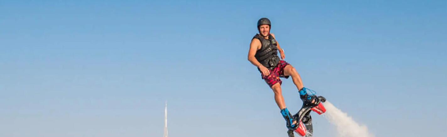 mężczyzna w kasku i kamizelce asekuracyjnej uprawiający flyboarding