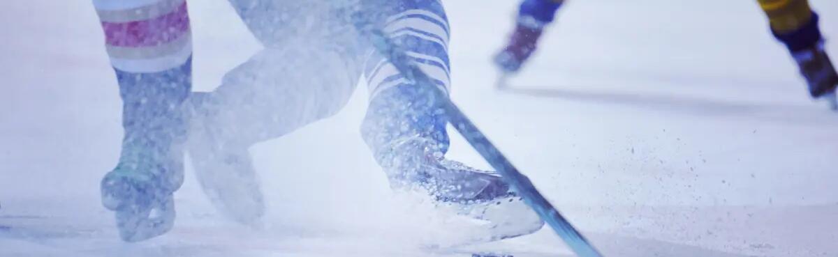 zawodnicy grający w hokeja na lodzie w łyżwach hokejowych