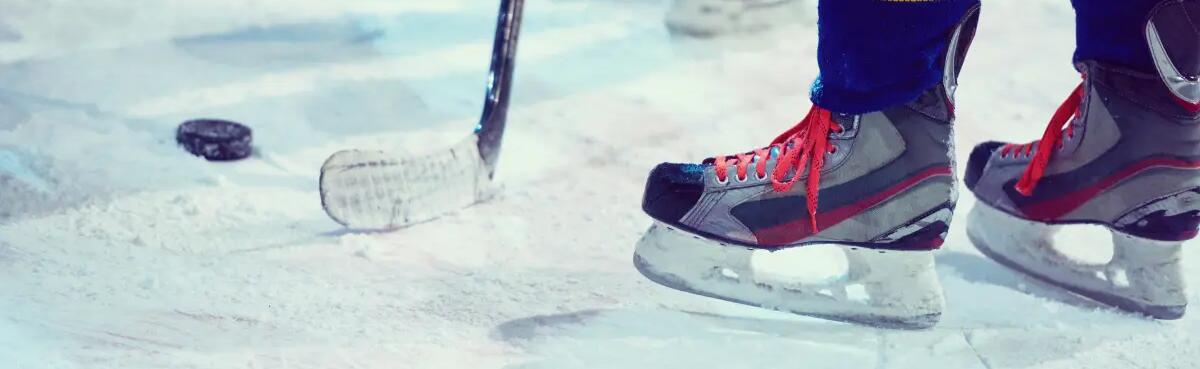 osoba stojąca na lodowisku w łyżwach hokejowych