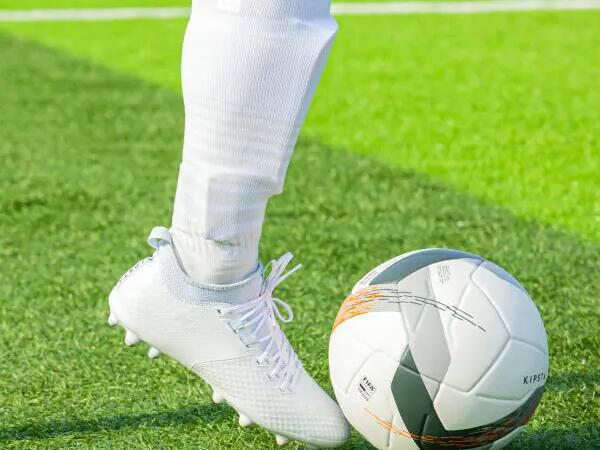 Man dribbling with shinpads on