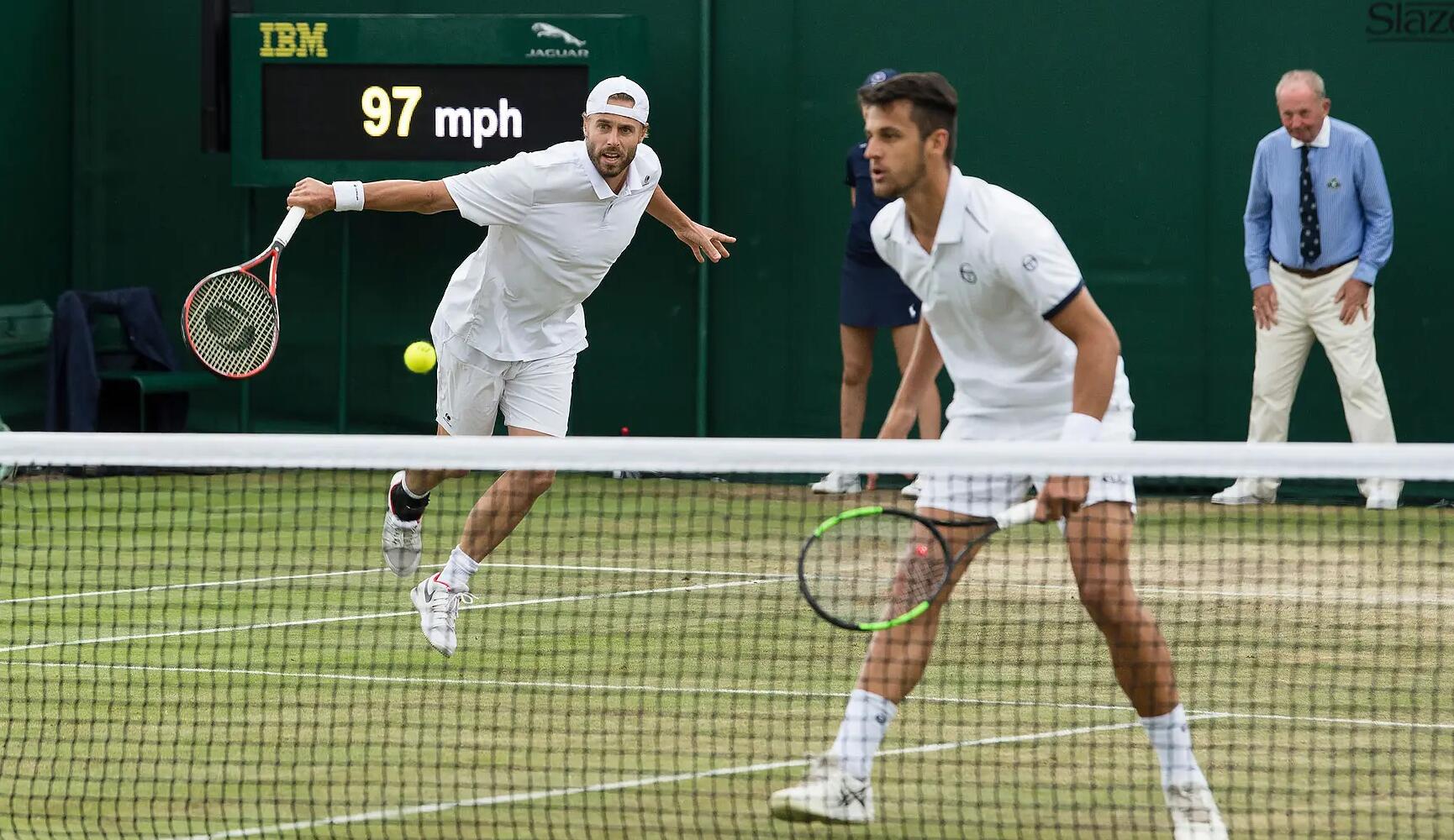 mężczyźni podczas turnieju tenisa ubrani w odzież sportową na korcie tenisowym