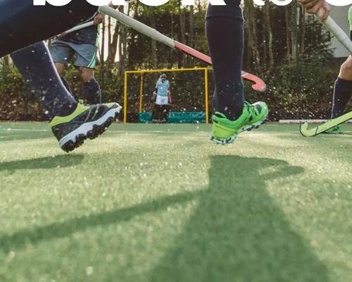 een team speelt veldhockey op een kunstgrasveld