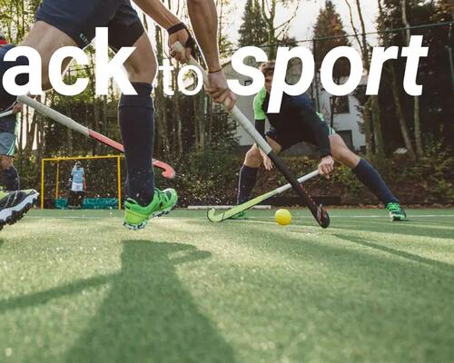 een team speelt veldhockey op een kunstgrasveld