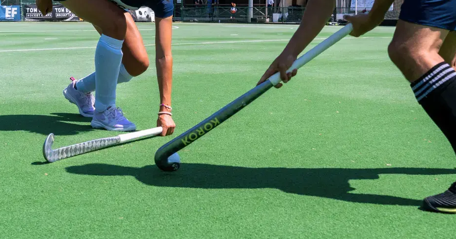 Twee hockeyspelers op een hockeyveld met hockeysticks van het Decathlon-merk Korok