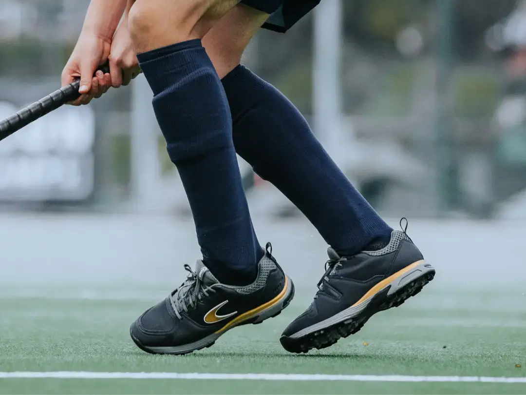 Een hockeyspeler met scheenbeschermers aan