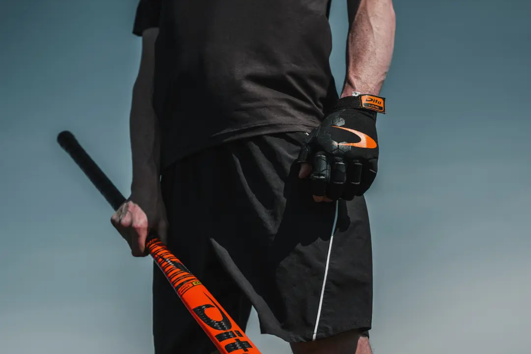 Een hockeyspeler met een stick en een veldhockeyhandschoen aan