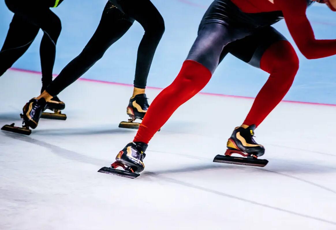Łyżwiarze w kostiumach i łyżwach do uprawiania łyżwiarstwa szybkiego