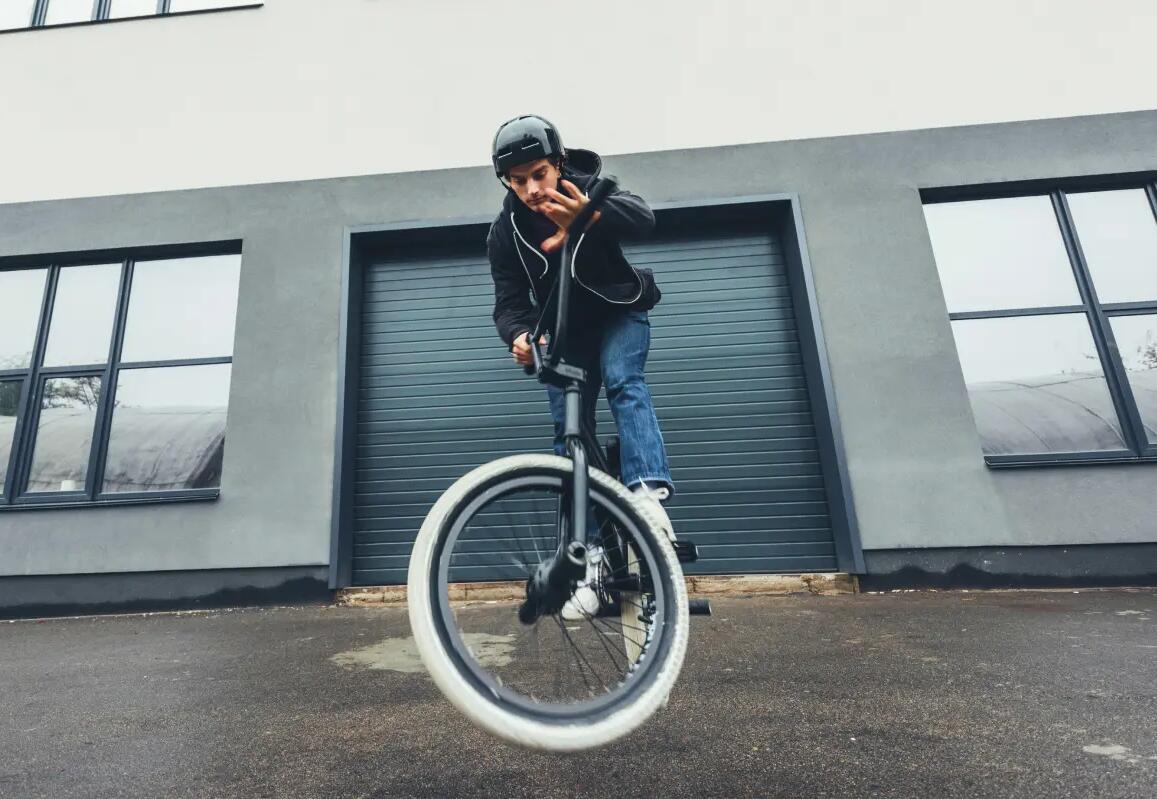Mężczyzna wykonujący trik na tylnym kole roweru bmx