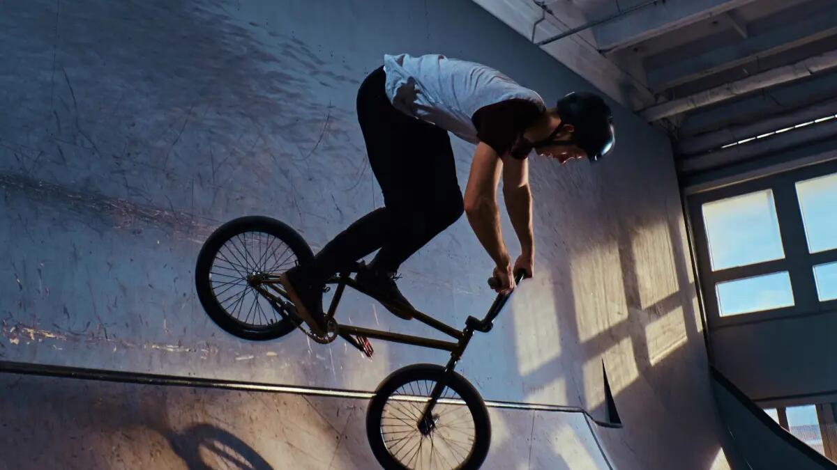 Chłopak w kasku jadący rowerem bmx po rampie rowerowej