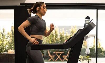 Mulher na esteira da academia com seu conjunto de roupa para treino feminino