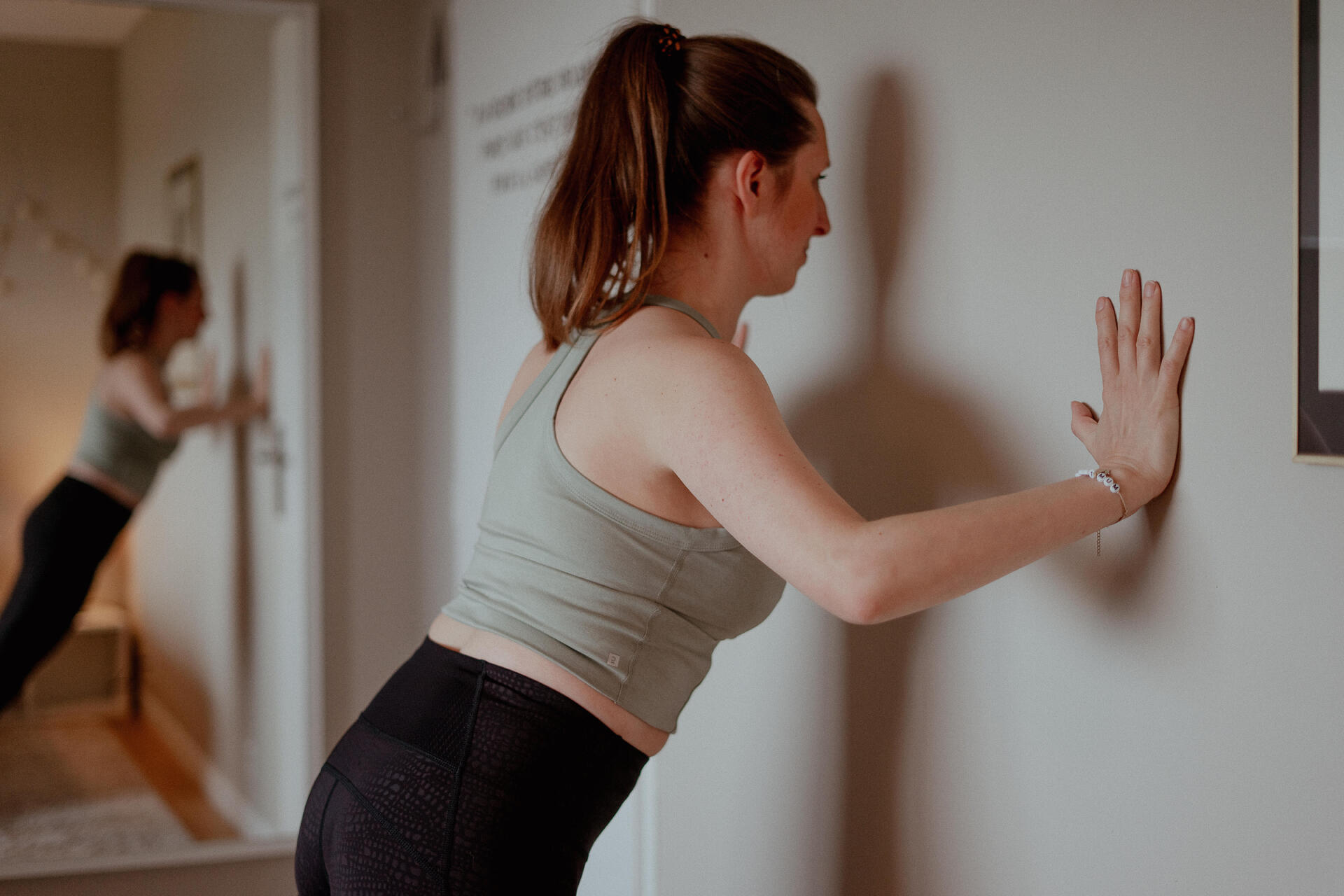 Kobieta ćwicząca pilates przy ścianie