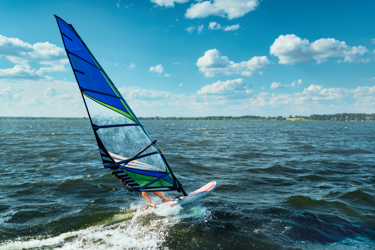 Auf offenem Meer ist eine Person auf einem Windsup unterwegs