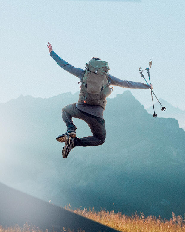 A guy jumping for joy in the mountains