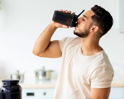 Mężczyzna pijący z bidonu zastanawiający się który suplement wziąć przed treningiem beta-alanine czy bcaa