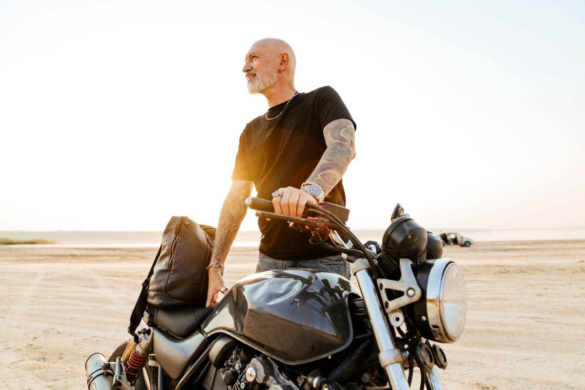 Motocyklista opierający się o motor z bagażem