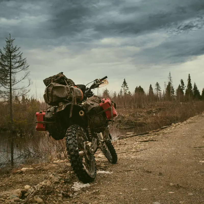 Motor stojący w plenerze obłożony bagażami z namiotem dla motocyklisty