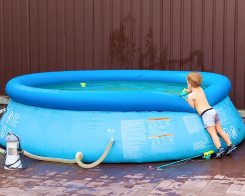 Dziecko bawiące się w basenie z podłączoną pompą do basenu