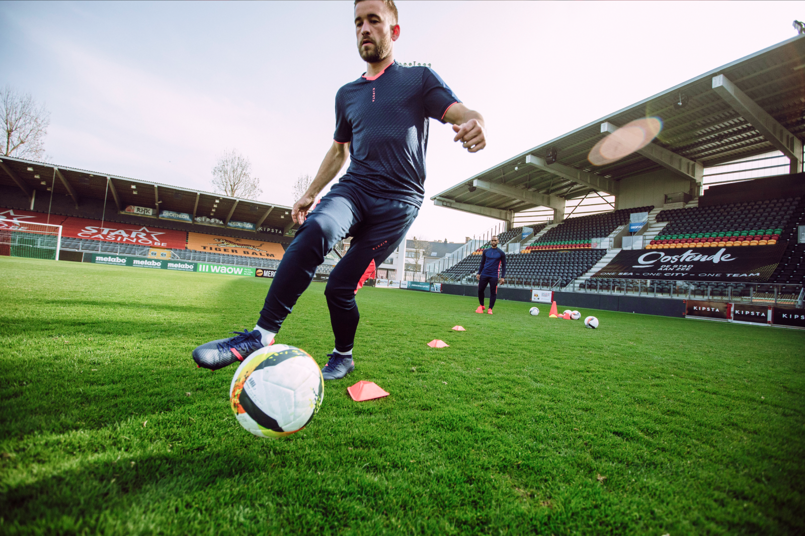 Mężczyzna w odzieży sportowej ćwiczący z piłką podczas treningu na boisku