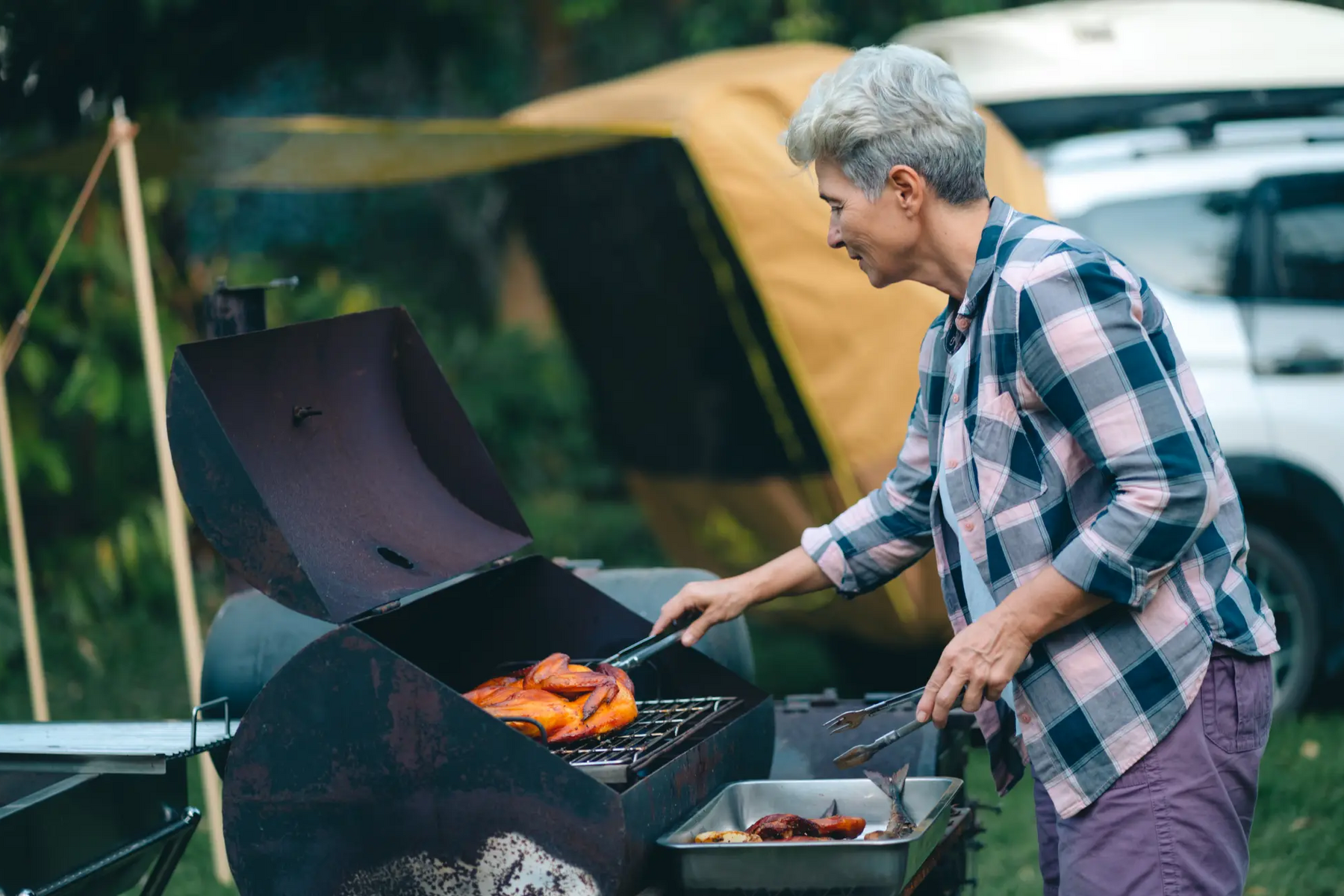 Kobieta grillujca kurczaka na grillu