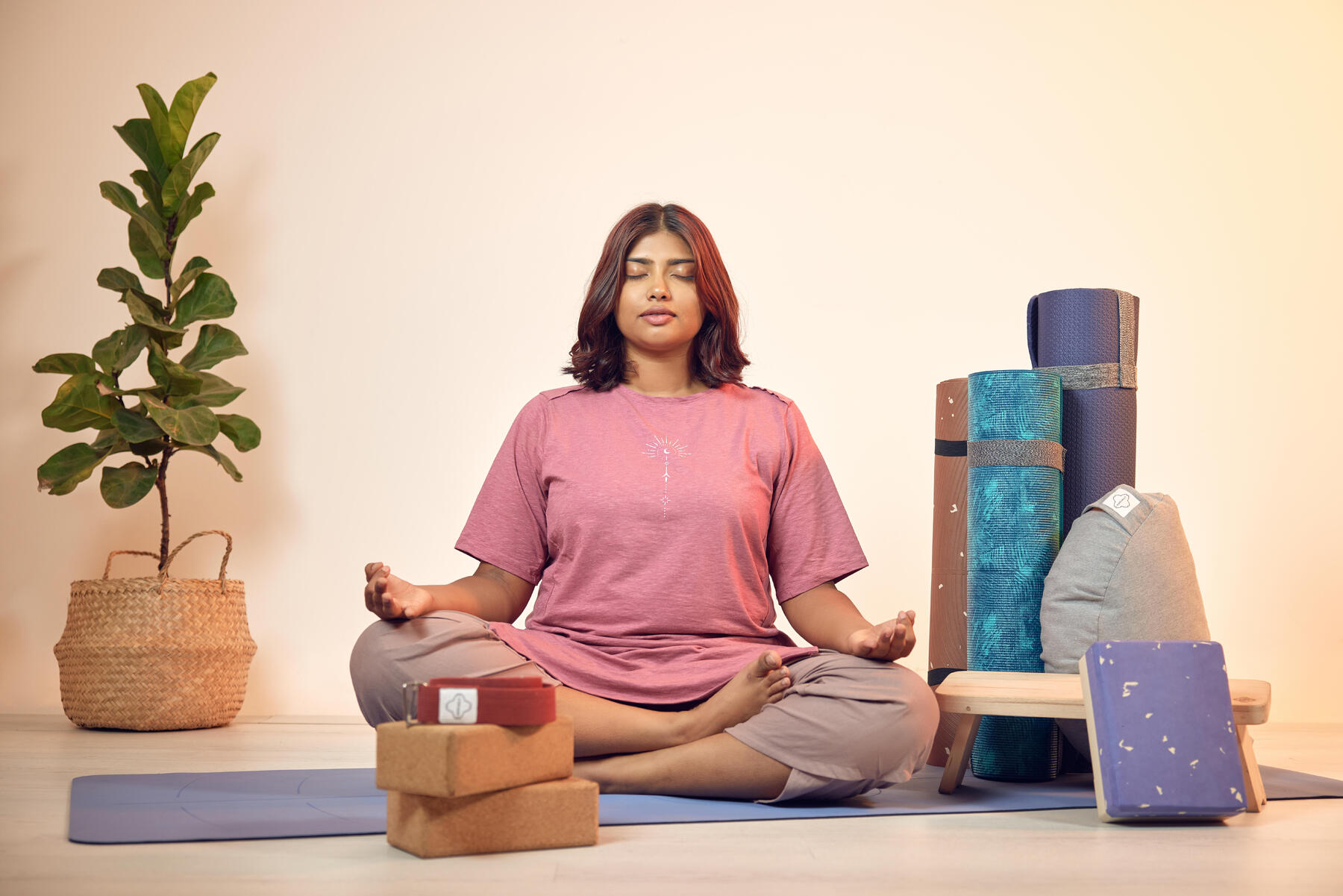 Kobieta siedząca na macie z założonymi nogami na siebie podczas treningu uważności mindfulness