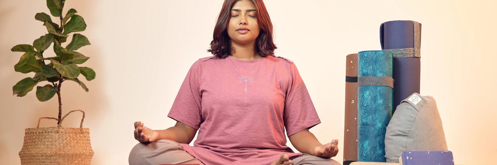Kobieta siedząca na macie z założonymi nogami na siebie podczas treningu uważności mindfulness