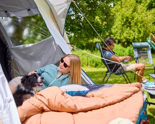 Man and woman setting up their tent outdoors
