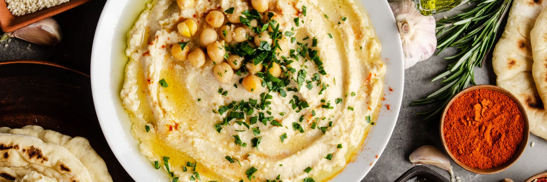 Humus z ciecierzycy w misce udekorowany zieleniną idealny na kolację wegetariańską