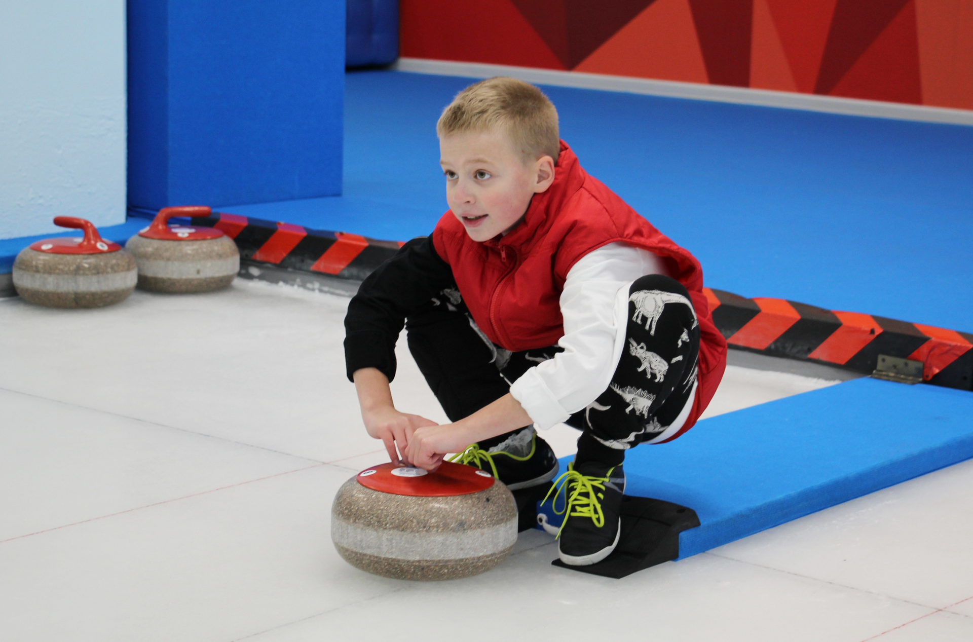 Chłopiec przygotowujący się do gry w curling