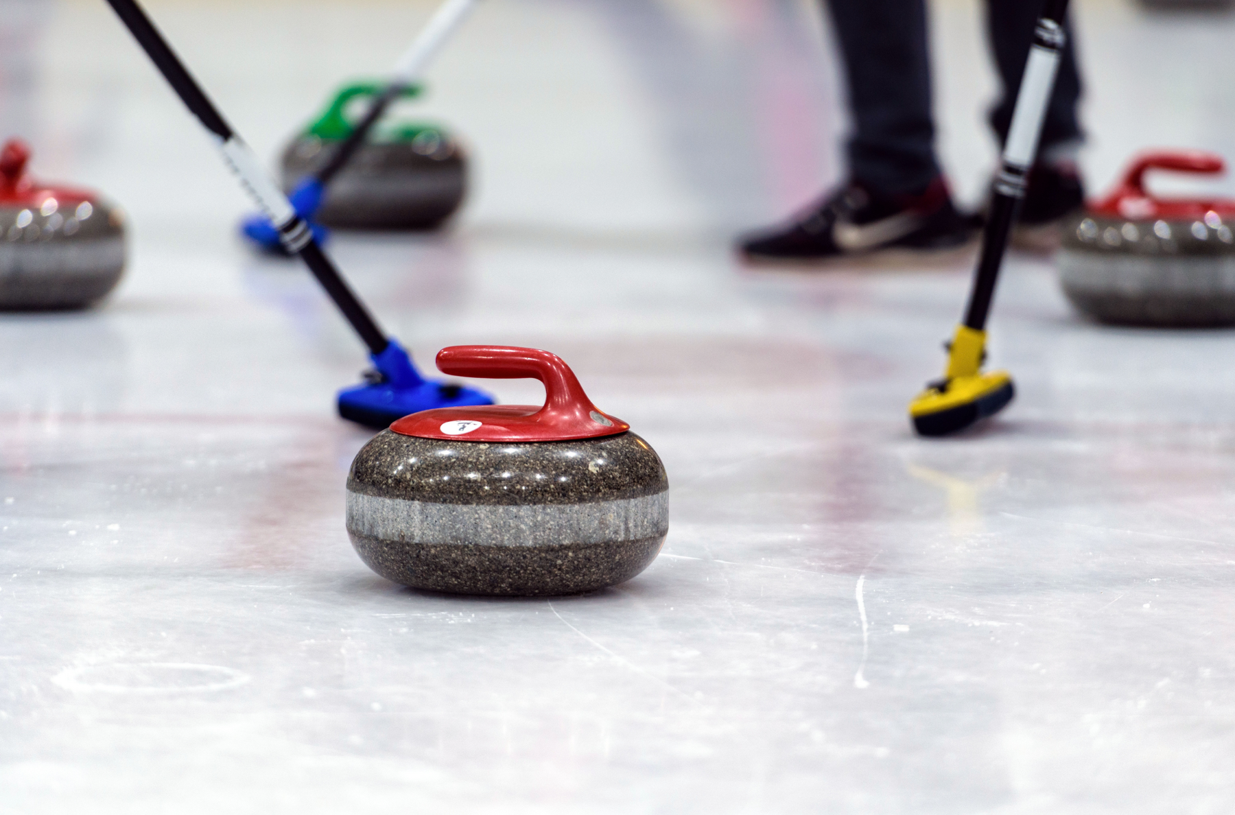 Grupa znajomych ucząca się grać w curling
