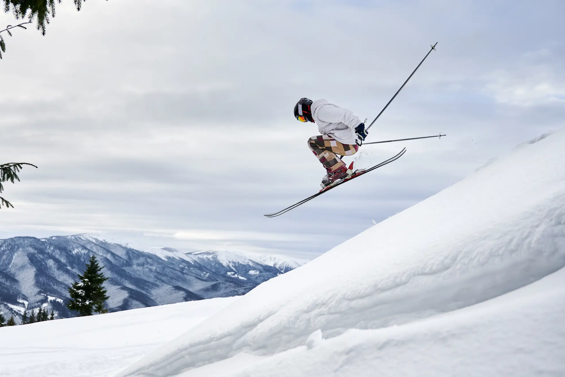 Mężczyzna trenujący freeskiing skaczący na nartach w maju