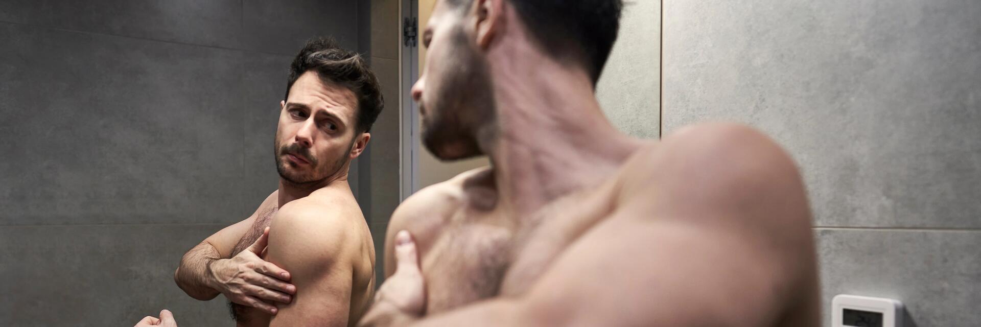 un homme se regarde dans le miroir