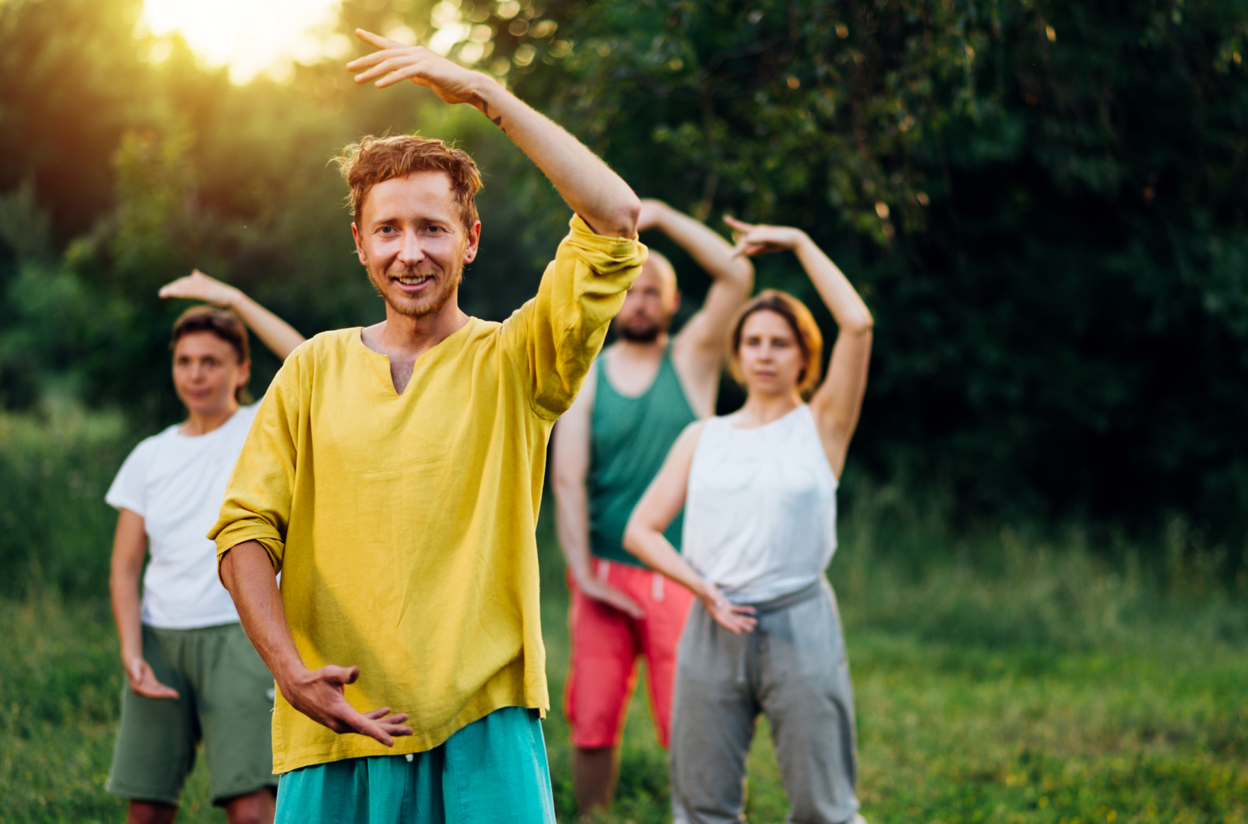 Grupa osób robiąca ćwiczenia qigong na świeżym powietrzu