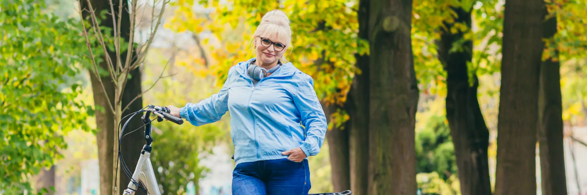 Kobieta stojąca przy rowerze chcąca zrzucić duży brzuch w okresie menopauzy
