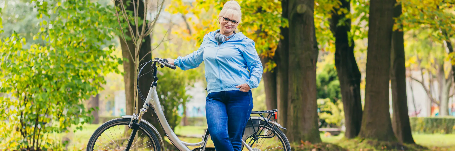 Kobieta stojąca przy rowerze chcąca zrzucić duży brzuch w okresie menopauzy