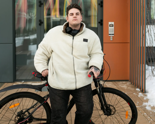 Otyły młody chłopak opierający się o rower