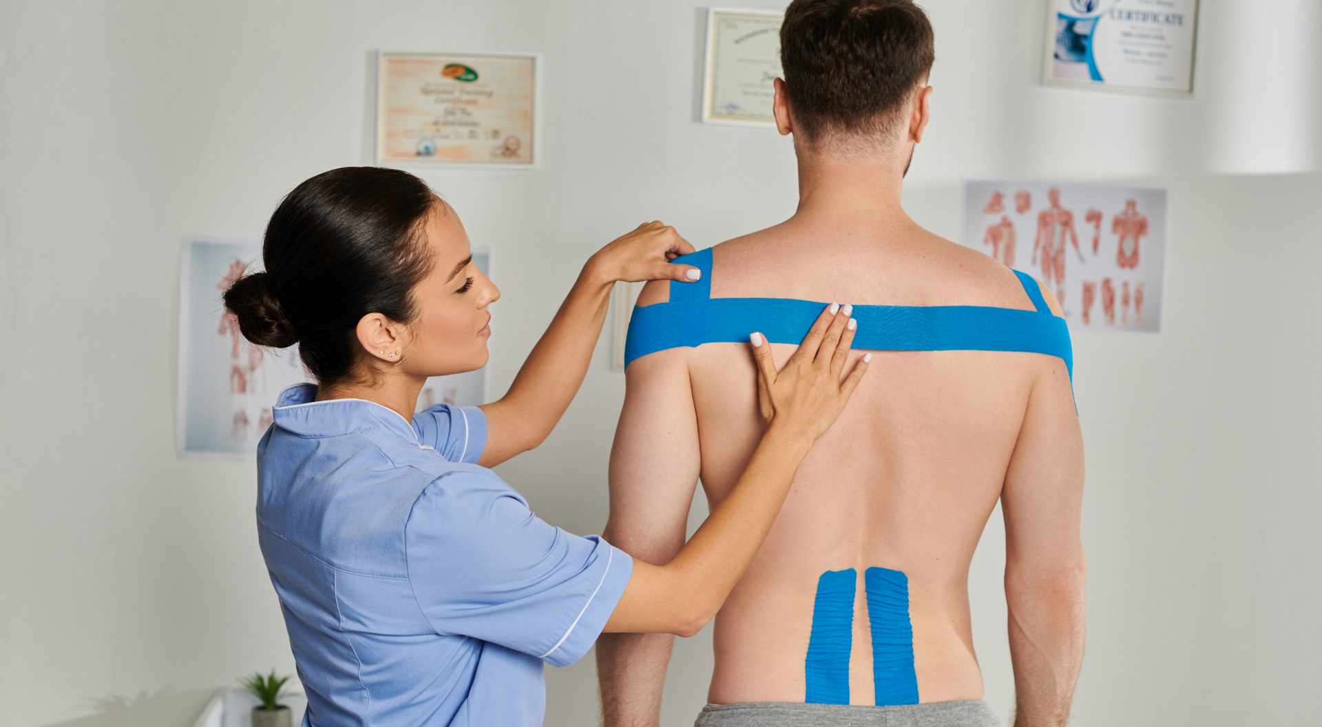 Fizjoterapeutka wykonująca kinesiotaping by zapobiec napadowi rwy kulszowej