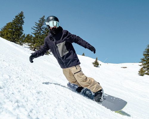 Mężczyzna zjeżdżający na desce w dopasowanych butach by uniknąć kontuzji w snowboardzie